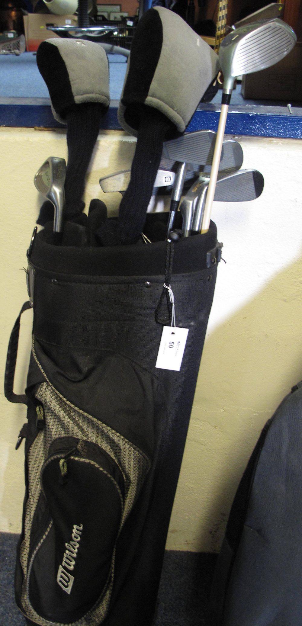 A Wilson golf bag containing a good selection of assorted Wilson golf clubs including three women'