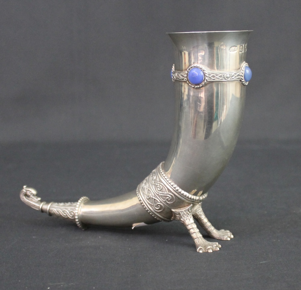 A QUEEN ELIZABETH II SILVER DRINKING HORN, with Celtic banded decoration and set with four blue