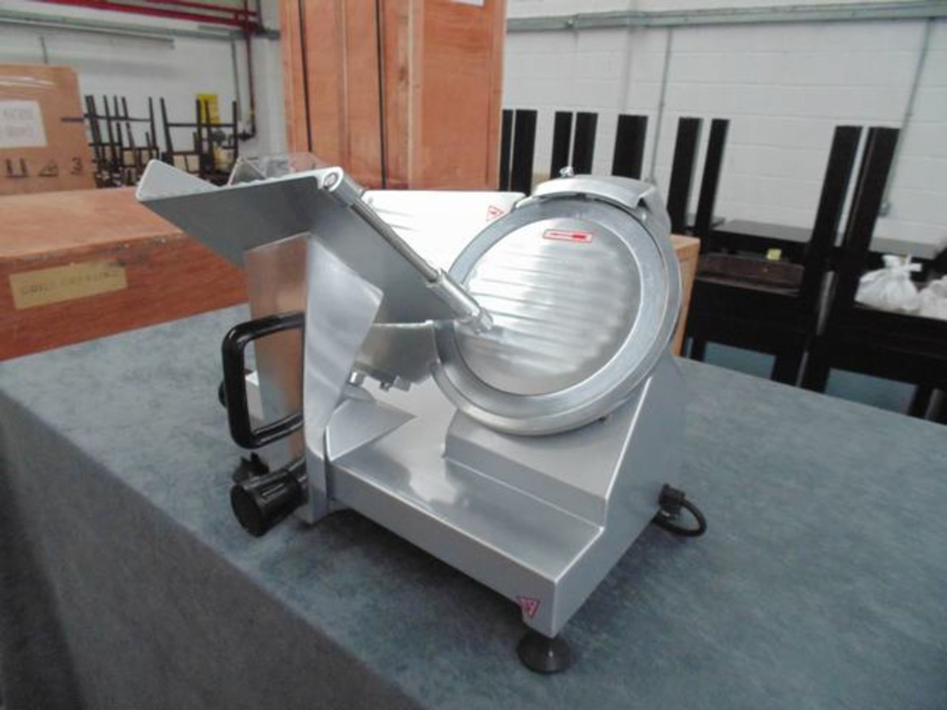 Commercial gravity fed slicer high carbon steel blade is hard chromed, with a hollow ground taper