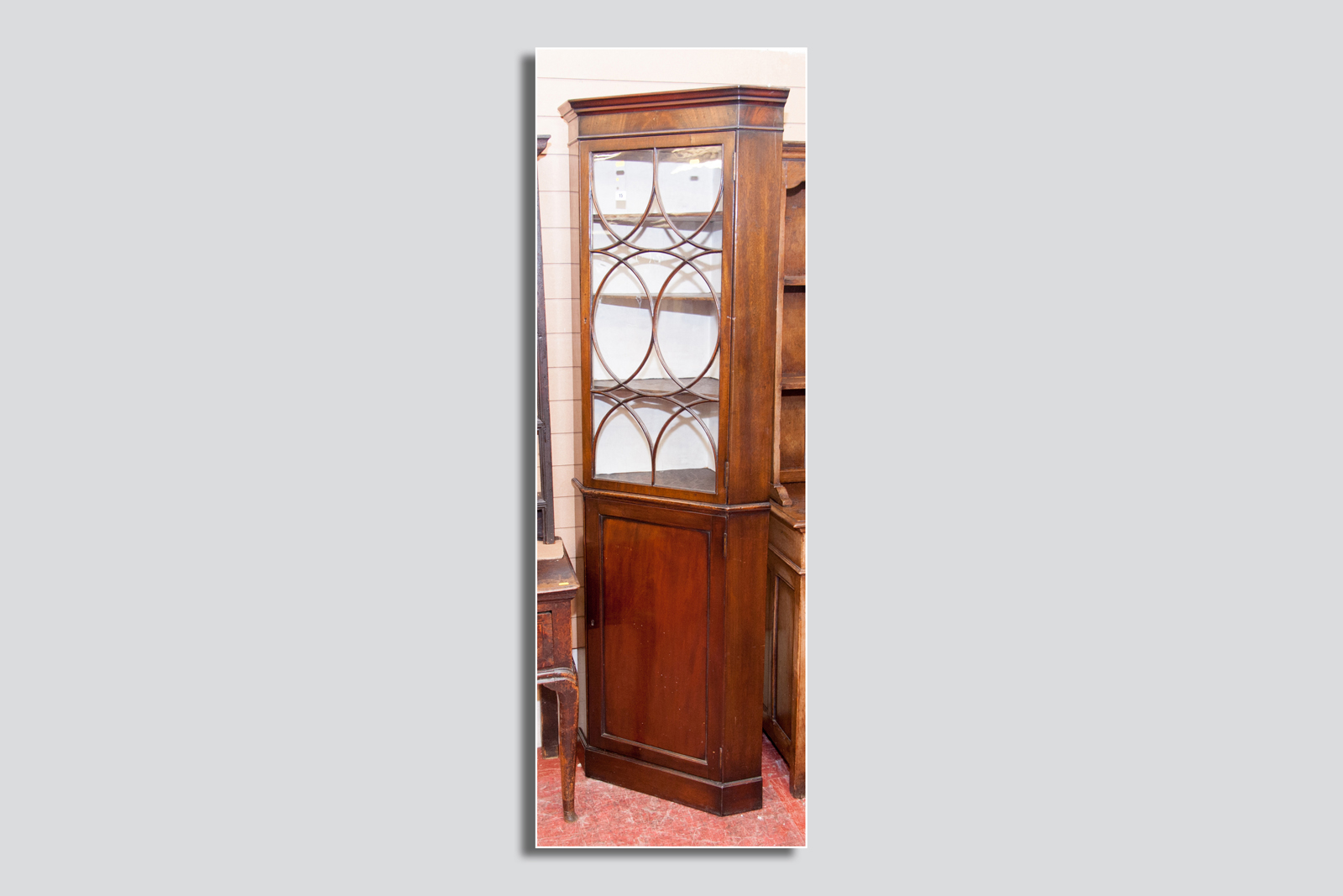 A one piece period mahogany glazed top corner cupboard, the glazed door having an interesting