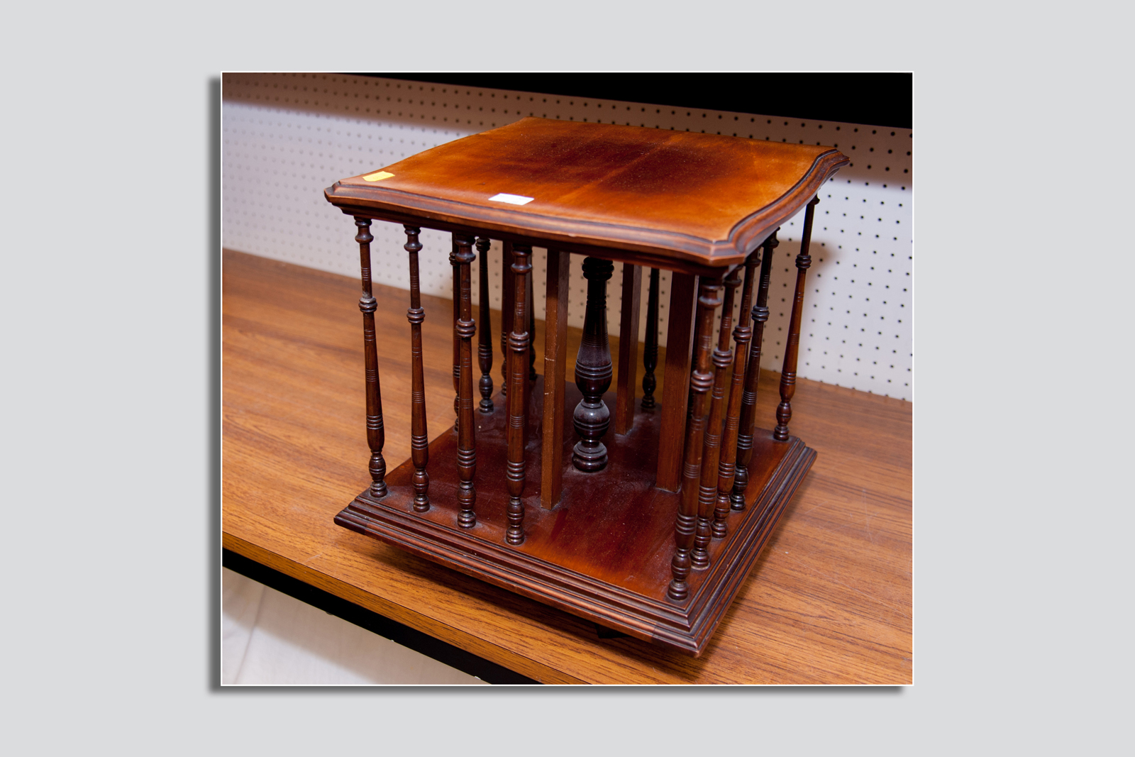 A small mahogany revolving bookcase, the polished top and base connected by turned spindle