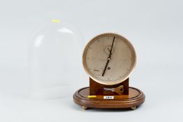 A four pillar brass mantel clock set on an oak plinth under a glass dome, the dial marked Thomas