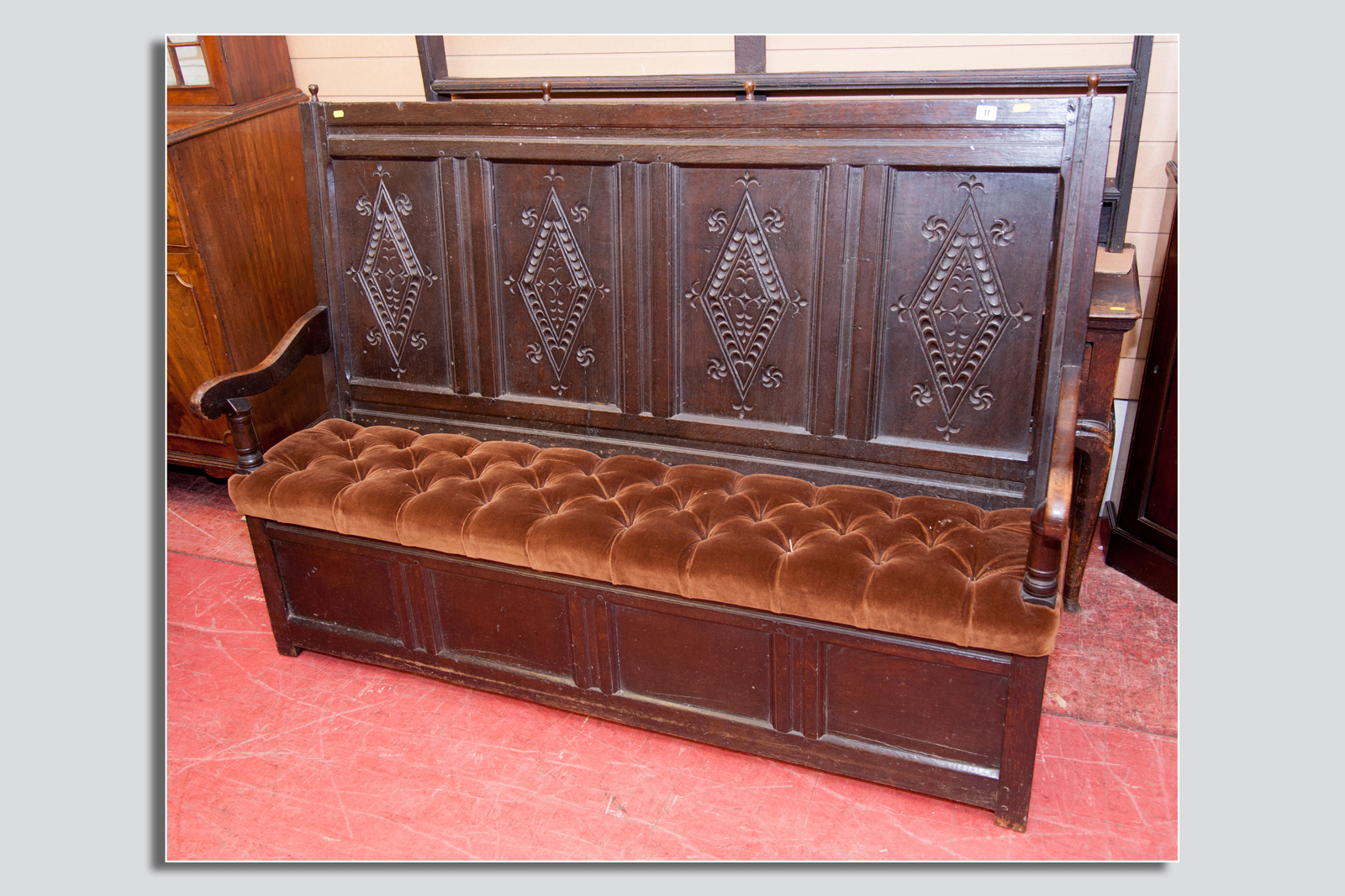 An early 19th Century oak bench having four separate panels with diamond carved motifs to the