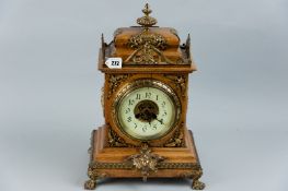 A French bracket clock in an oak case, profusely decorated with ormolu brass mounts, a finial top