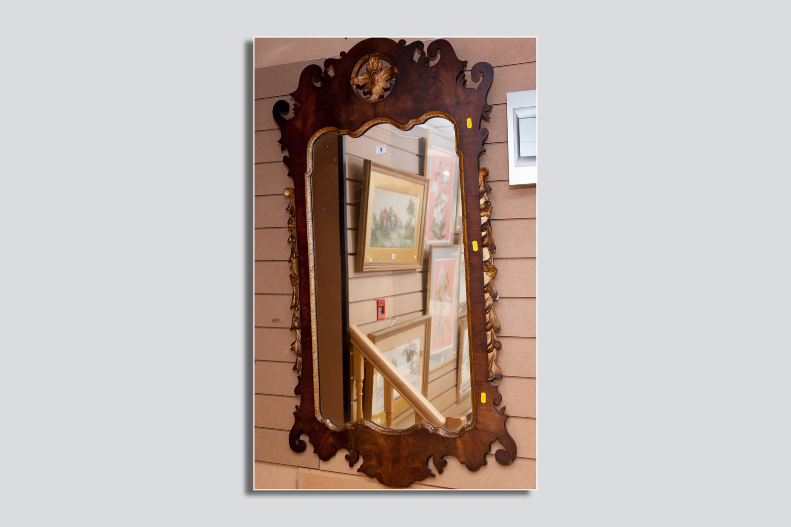 A large Georgian walnut and gilt decorated wall mirror, the fretwork frame edged with floral leaf