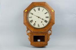 An eight day drop dial two spring wall clock within an oak case having a painted dial with carved