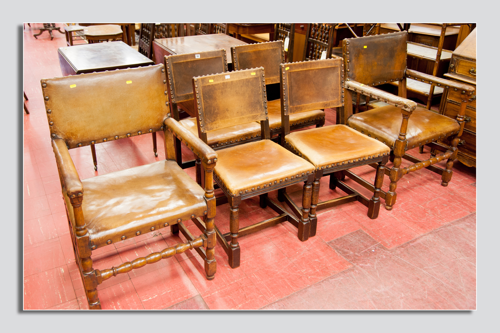 A set of six (four plus two carvers) rustic style turn leg chairs with button leather seats and