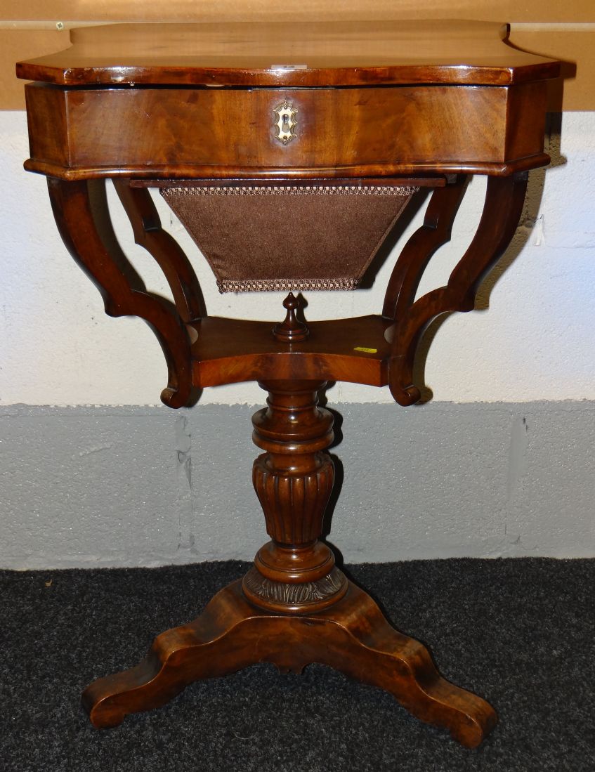 A fine Victorian mahogany work-table, the hinged-top raised upon four scrolled supports, serpentine