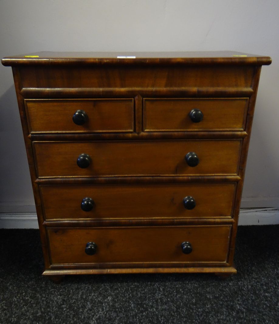 A neat antique mahogany apprentice chest of three long and two short drawers with ebonised turned