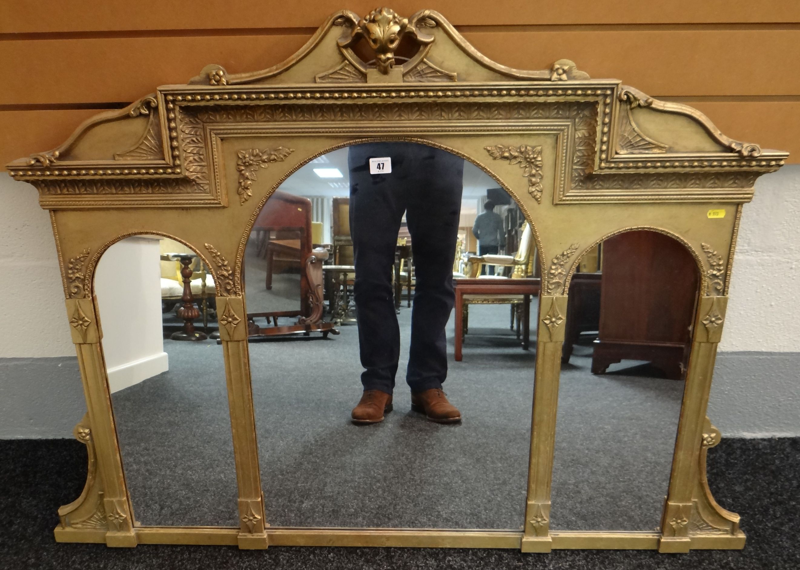 A 20th century elaborately decorated gilt-framed three section wall mirror having three arched