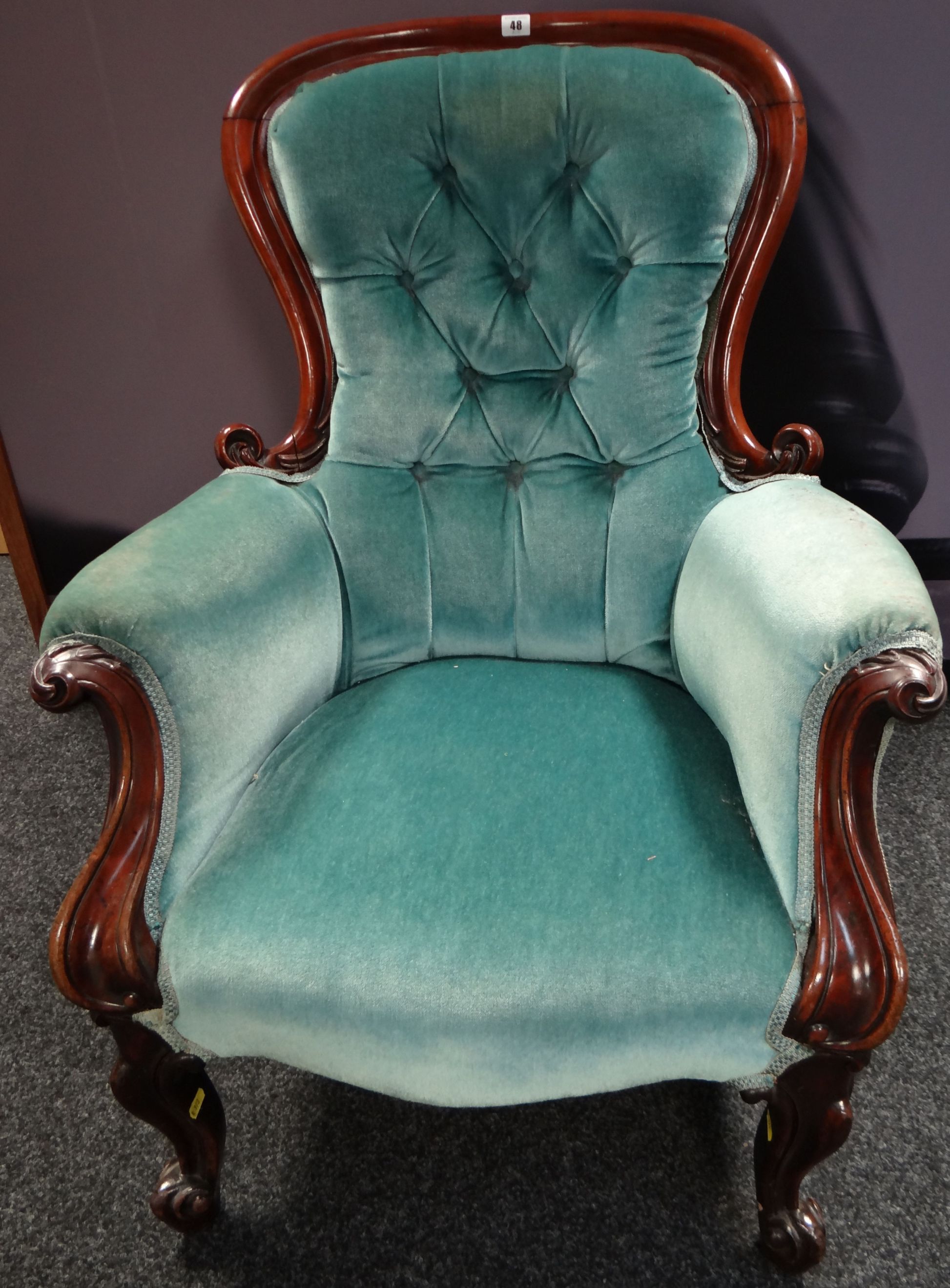 A mahogany framed spoon-back buttoned armchair