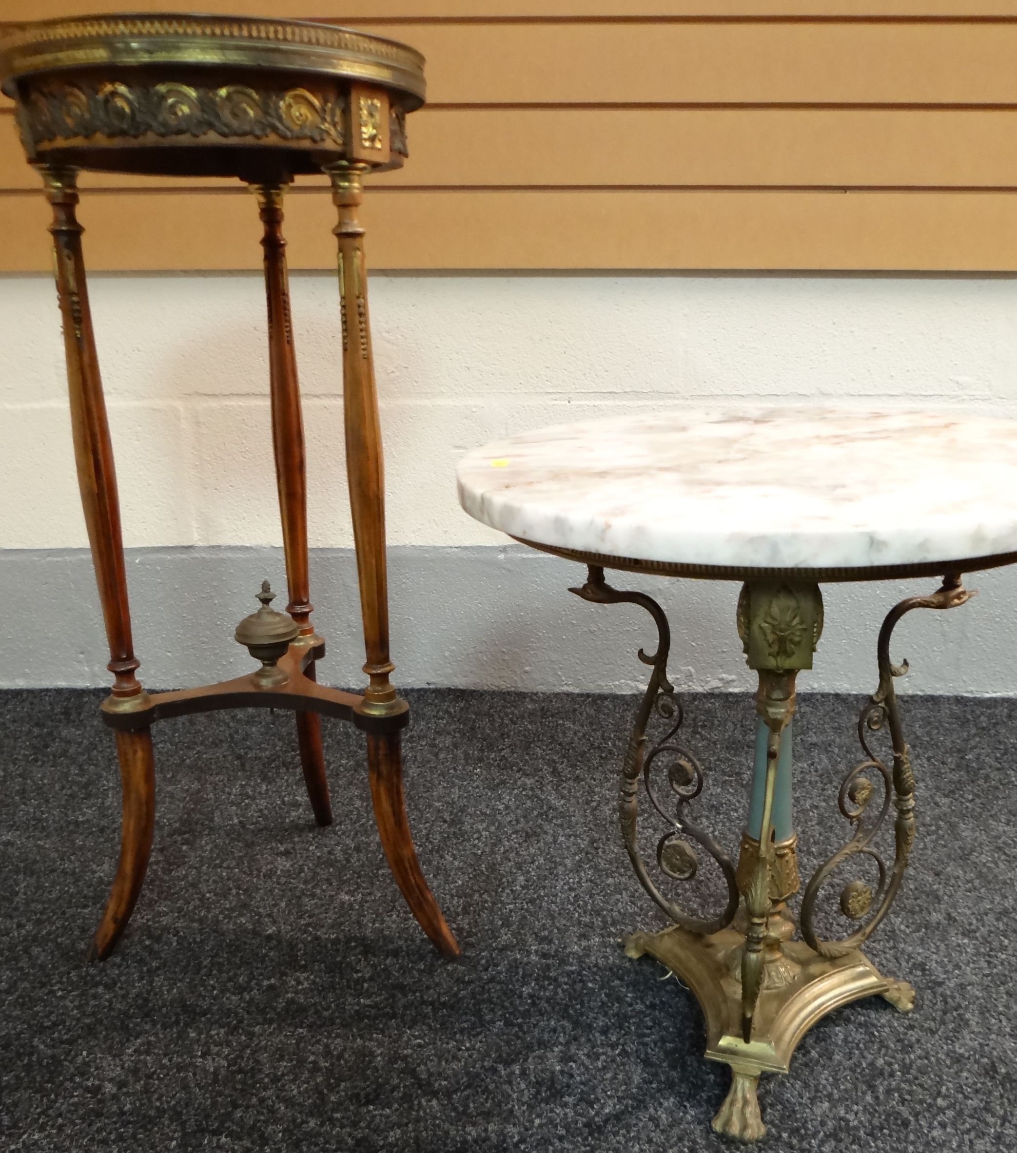 Two ornate marble-topped circular tables, one with elaborate metallic and marble support, the other