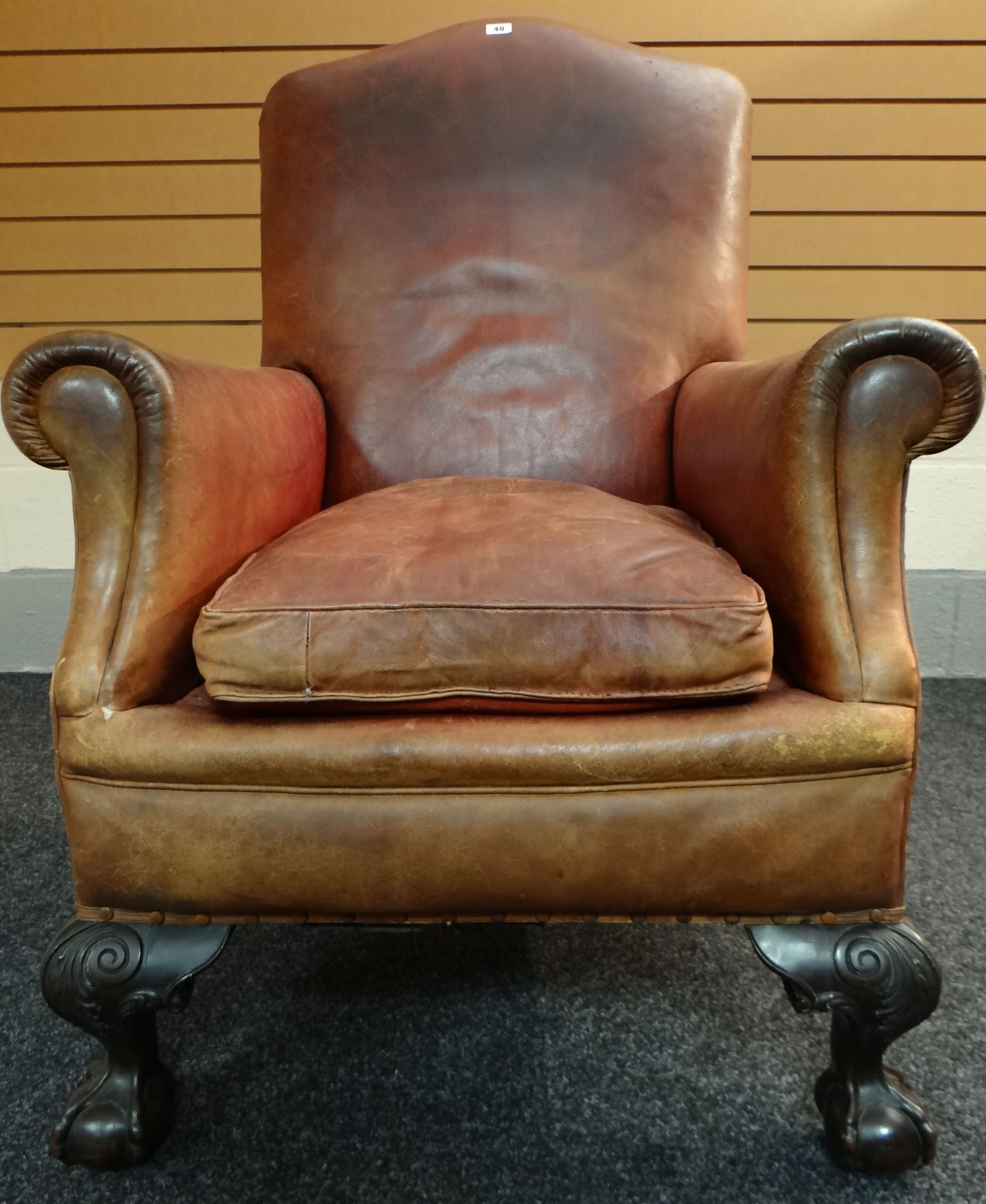 A turn of the century brown leather club-style armchair on carved and ball-and-claw supports