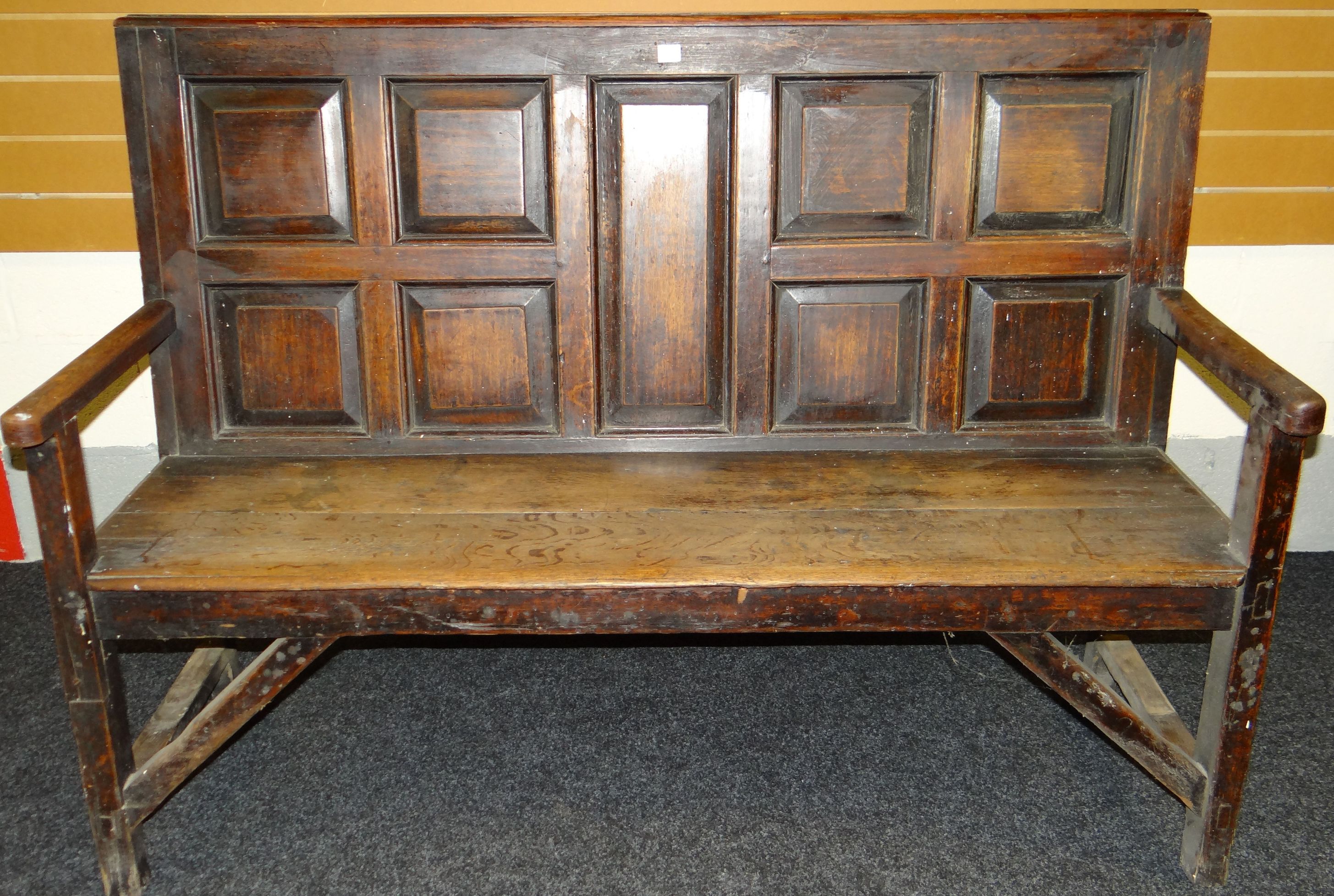 An early 19th century Welsh farmhouse settle, the back with nine fielded panels, width 58ins (