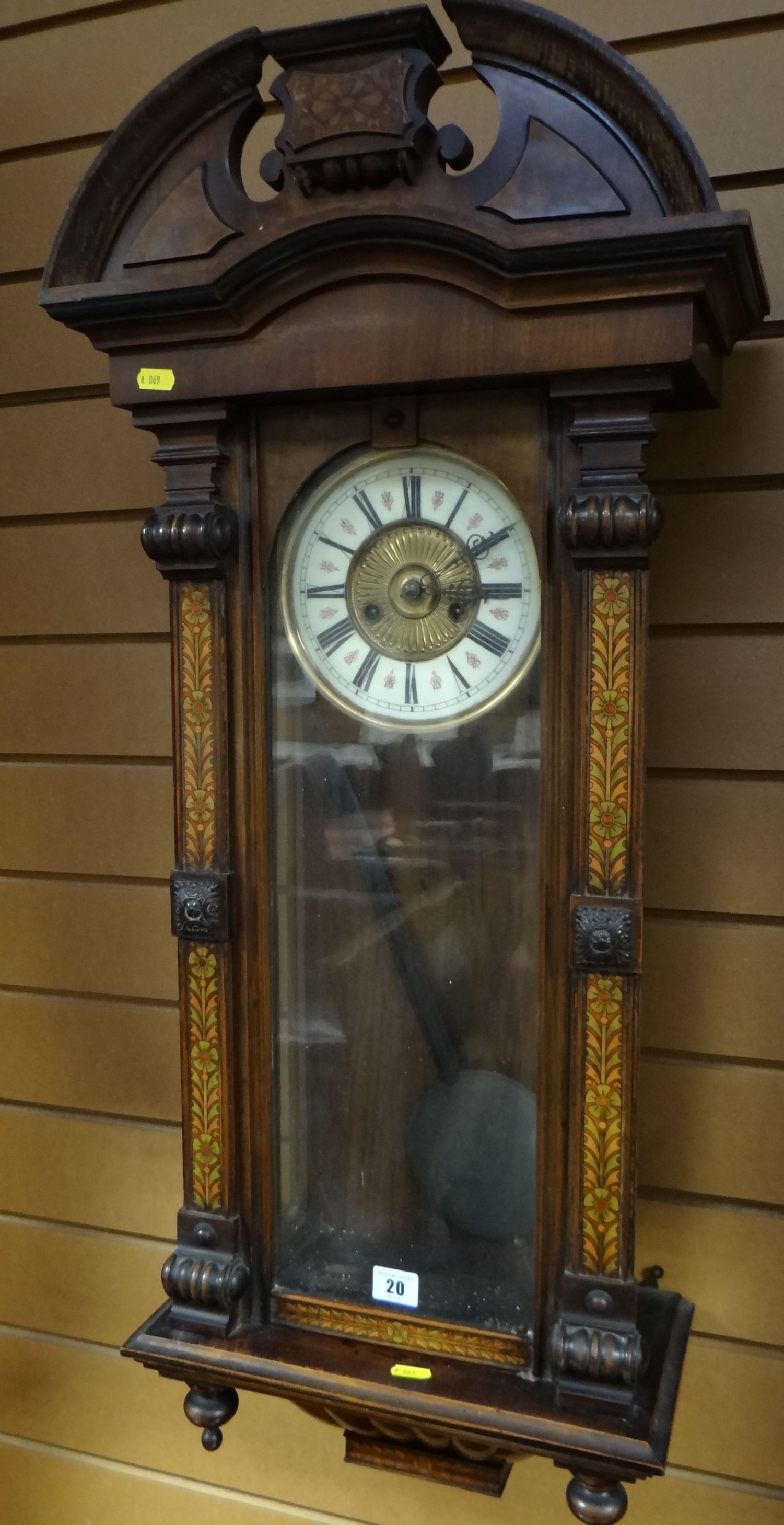 A painted mahogany pendulum wall clock, the brass and enamel circular dial with Roman Numerals,