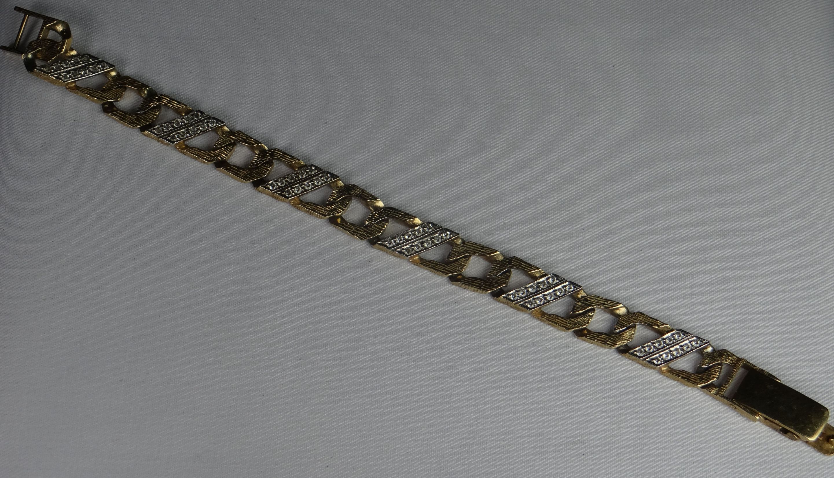 A 9ct yellow `crusty` gold link bracelet with twelve rows of tiny diamonds, 30.3gms