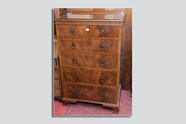 A 1950`s walnut chest of five drawers with brass ring handles