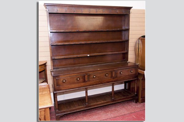 A polished and later stained oak potboard dresser base having three drawers with brass handles to a