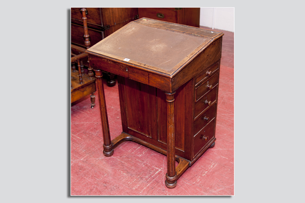 A polished Davenport style desk with turned supports