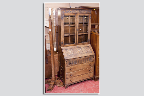 A polished rustic linenfold bookcase bureau having two glazed upper doors each with six panels to a