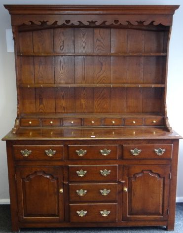 A good polished oak reproduction Welsh dresser, the base having a pair of fielded panelled cupboard