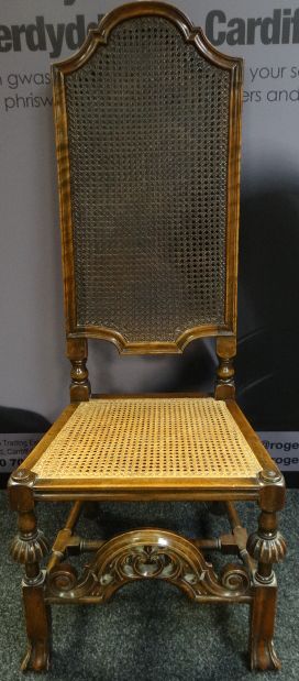 A high-back Bergere hall chair with the cane-back of shaped-form and with carved and block supports