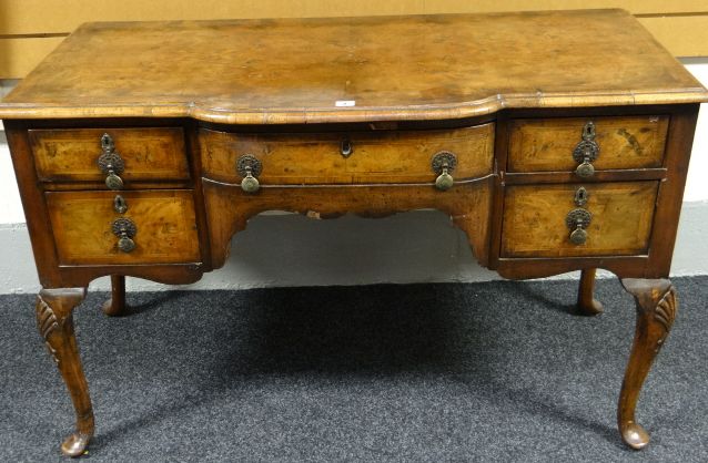 A Queen Anne style walnut breakfront dressing table or kneehole desk on acanthus carved cabriole