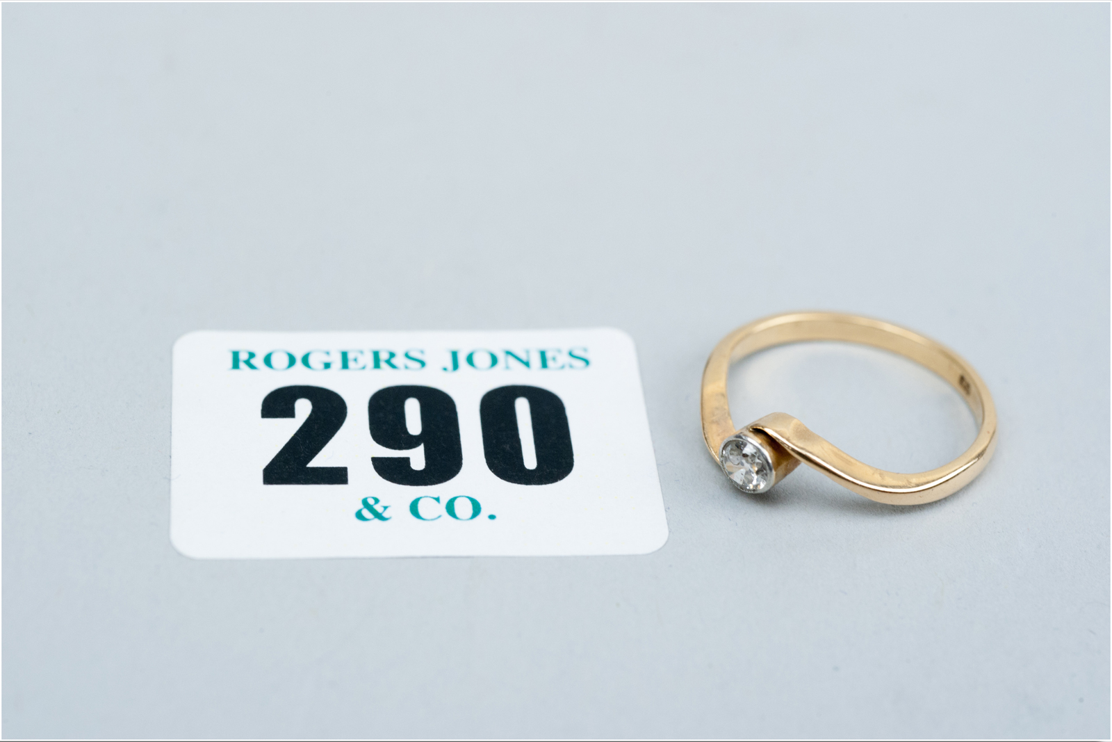 An eighteen carat gold round cut diamond solitaire crossover ring, visual estimate 0.3 carat