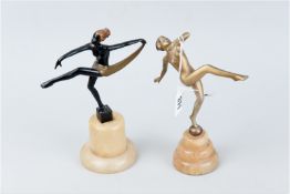 Two metal Art Deco dancing ladies, one painted gold and the other painted black with a gold skirt,