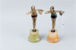 Two Art Deco metal figures of typical form of ladies in swimsuits holding a fan on alabaster