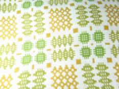 A wool Welsh tapestry blanket in traditional cream and with green and mustard geometric patterns