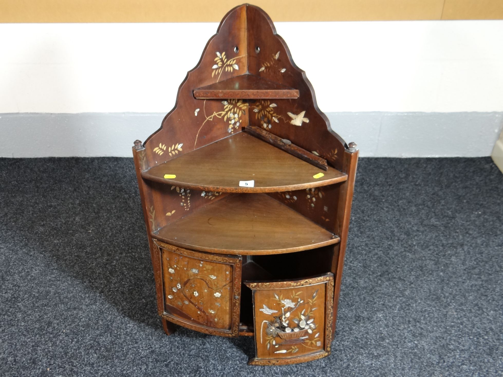 A small wooden Japanned standing corner cupboard and trinket shelf with applied mother-of-pearl