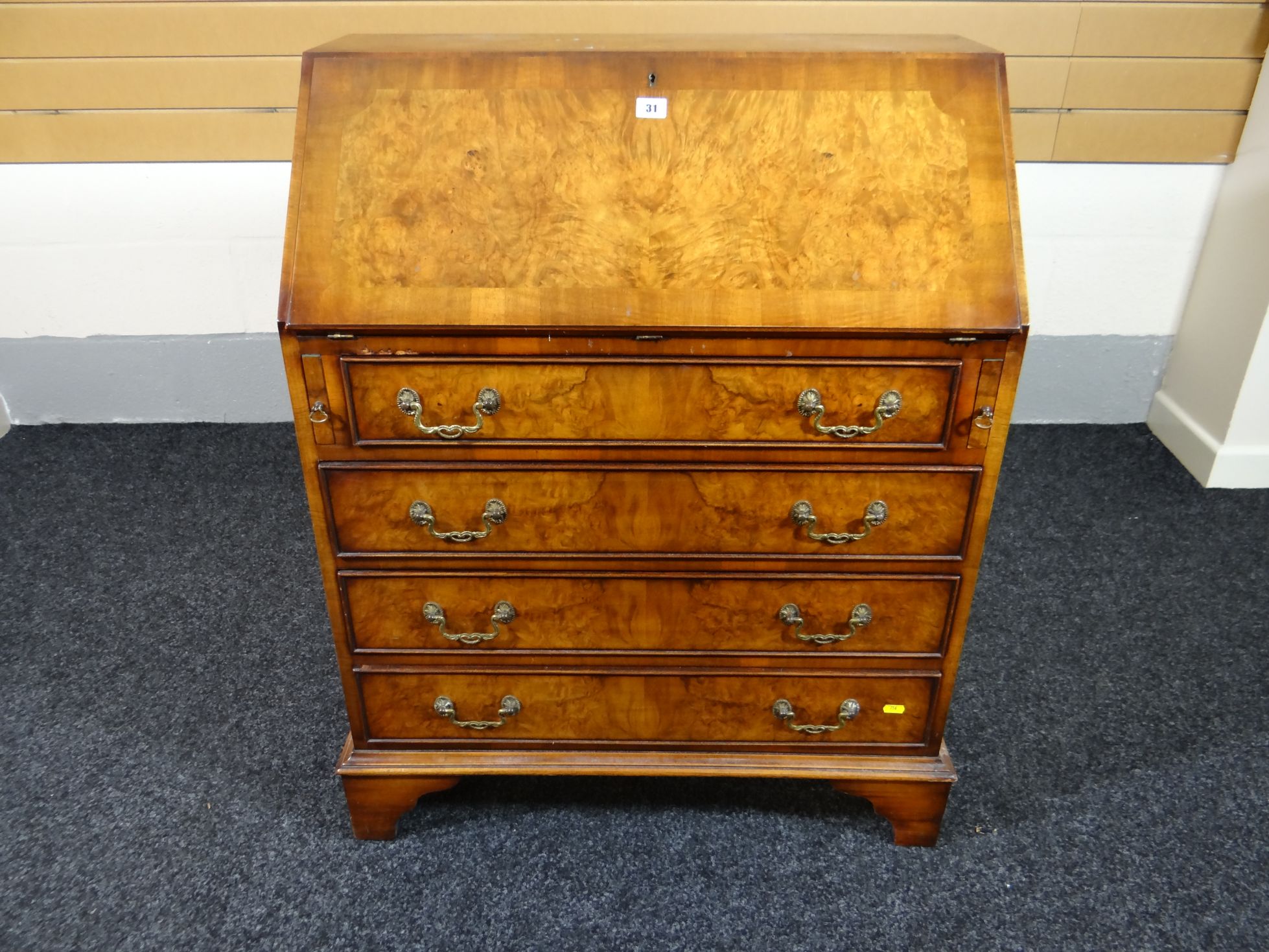 A good reproduction polished walnut sloped bureau with four long drawers and neat interior