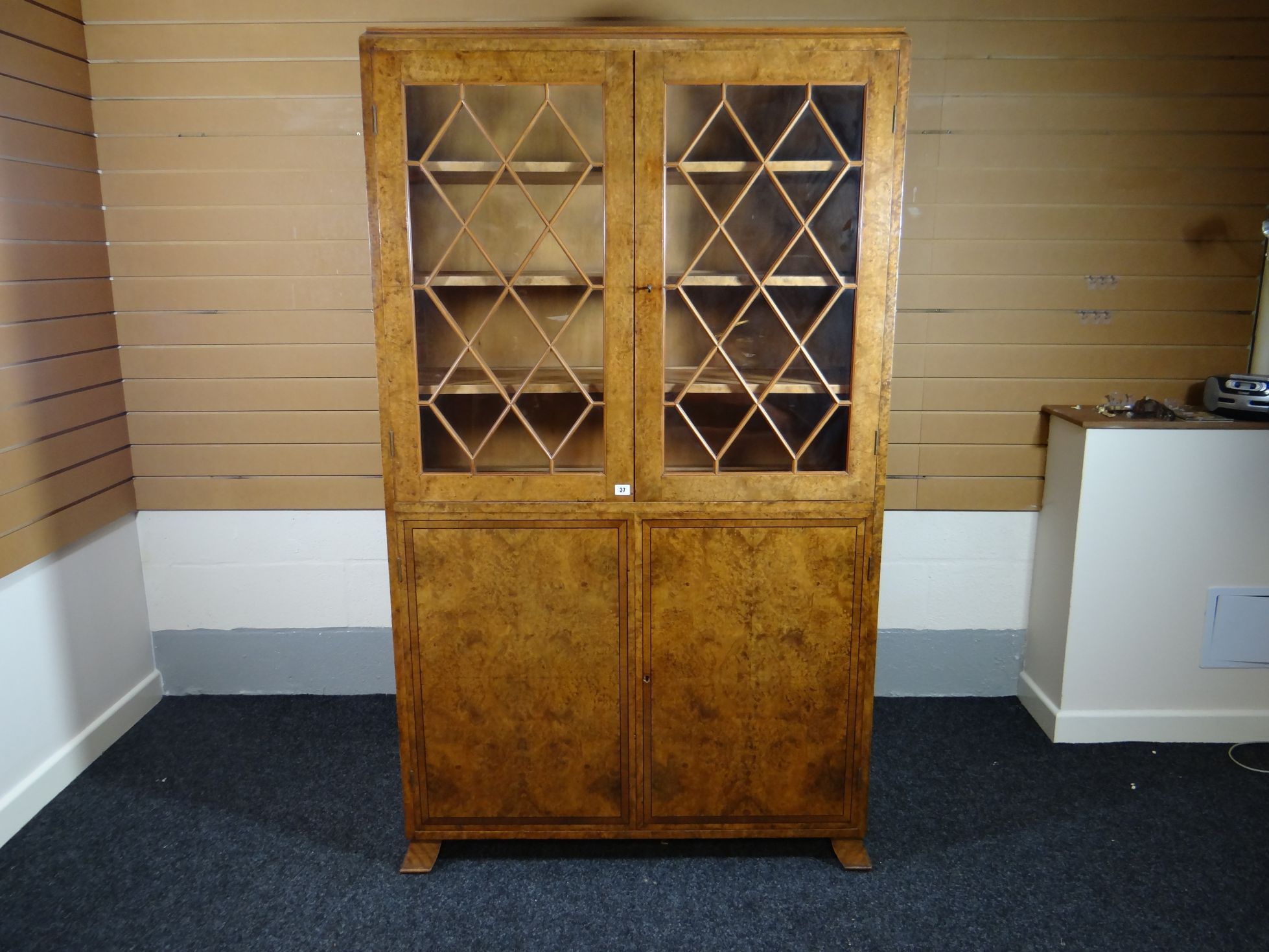 A fine quality Edwardian cross-banded walnut bookcase cupboard, the upper section with two diamond-