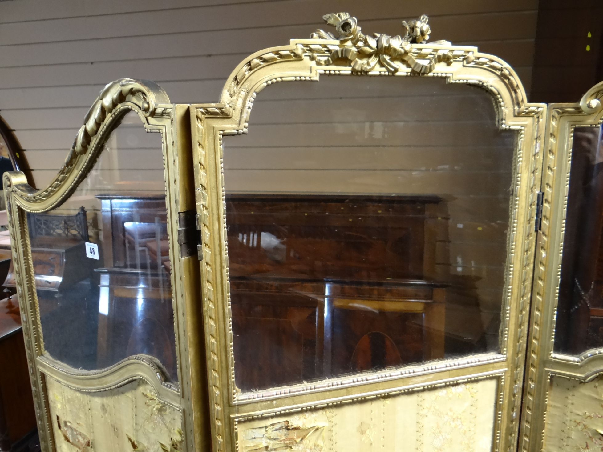A three-fold gilt-framed semi-glazed dressing screen of shaped form and with applied ribbon and - Bild 2 aus 2