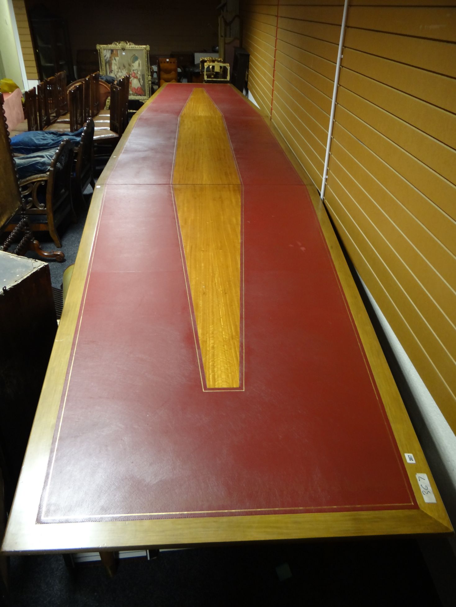 A mid-to-late twentieth century 25-foot long three-section boardroom table with tapering ends and