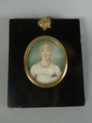 A Georgian miniature half-portrait of a lady in white dress and wearing coral beads, inscribed