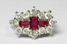 An 18ct white gold ruby and diamond cluster ring, the three central ruby baguettes forming a cross