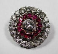 A fine ruby and diamond circular floral brooch, the centre diamond with visual estimate of 0.6ct