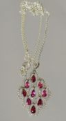 A fine necklace with abstract pendant, the nine pear-shaped rubies suspended within a white metal