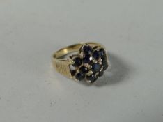 A 9ct yellow gold bark textured ring with a cluster of sapphires in a floral design