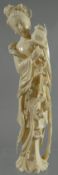 A finely carved ivory figure of a robed Guanyin scattering flowers from a basket, 10ins high (26cms)