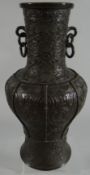 A Chinese bronze baluster vase with interlocking ring-handles and profusely decorated with geometric