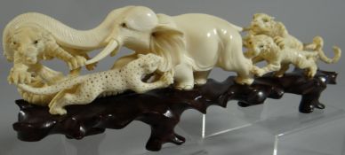 A finely carved ivory of an elephant endeavouring to fend off four ferocious tigers and a leopard