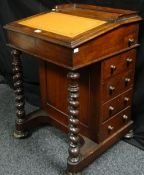 A Victorian mahogany Davenport desk having a narrow moulded back rail with a shallow slope front (