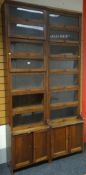 A pair of very tall stackable library bookcases in the `Globe Wernicke` style with base cupboards