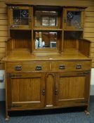 An Arts and Crafts style sideboard, the base having two cupboards below two drawers all below a rack