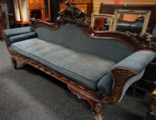 A mid nineteenth century colonial settee, having a serpentine shaped back, heavily carved all-