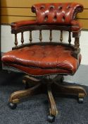 A red-leather buttoned captain-style swivel office armchair
