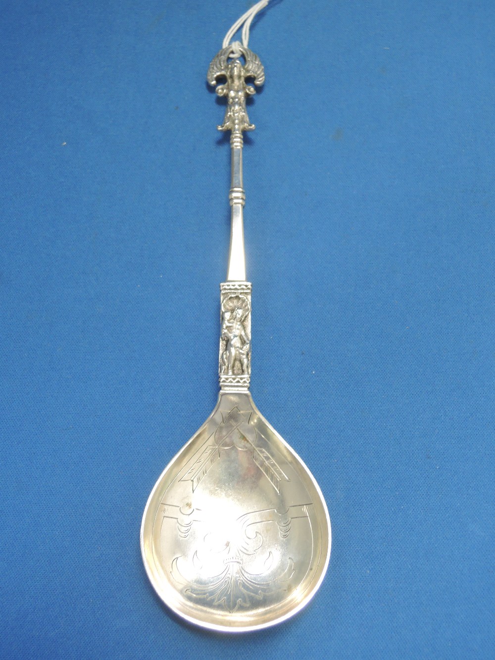 A Continental white metal spoon stamped 830 having religious/cherubic decoration
